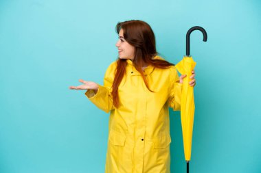 Mavi arka planda şemsiyesi olan kızıl saçlı bir kadın.