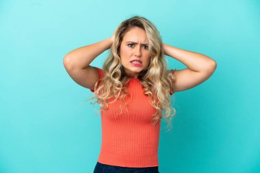 Mavi arka planda izole edilmiş genç Brezilyalı kadın gergin hareketler yapıyor.