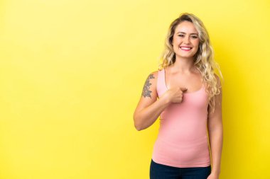 Sarı arka planda yalıtılmış Brezilyalı genç bir kadın. Sürpriz bir yüz ifadesi var.