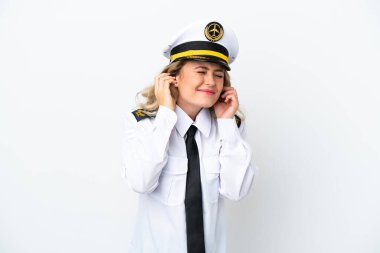 Brezilya uçağı pilotu, beyaz arka planda izole edilmiş, hayal kırıklığına uğramış ve kulaklarını kapatmış.