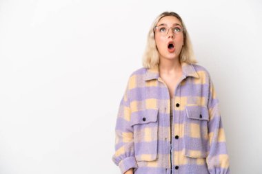 Beyaz arka planda izole edilmiş genç beyaz kadın yukarı bakıyor ve şaşırmış bir ifadeyle