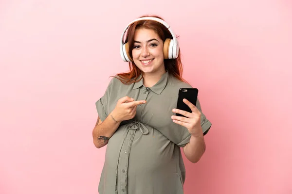 Young Redhead Caucasian Woman Isolated Pink Background Pregnant Listening Music — 스톡 사진