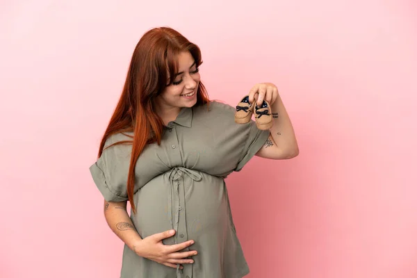若いです赤毛Caucasian女性隔離上のピンクの背景妊娠中や保持赤ちゃんおっぱい — ストック写真