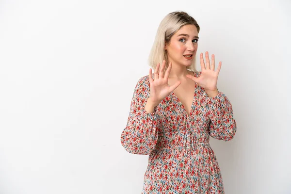 Beyaz arka planda izole edilmiş genç beyaz kadın ellerini öne uzatıyor.