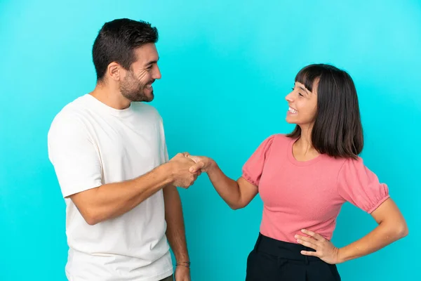 Young Couple Isolated Blue Background Handshaking Good Deal — Stock fotografie