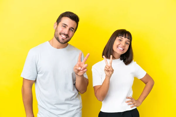 Young Couple Isolated Yellow Background Smiling Showing Victory Sign — ストック写真