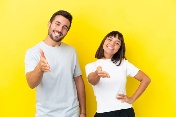 Young Couple Isolated Yellow Background Shaking Hands Closing Good Deal — ストック写真
