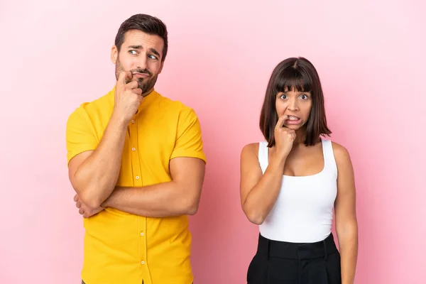 Casal Jovem Isolado Fundo Rosa Com Dúvidas Olhar Para Cima — Fotografia de Stock