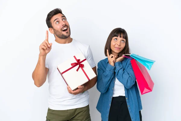 Young Couple Holding Shopping Bags Present Isolated White Background Pointing — Stockfoto