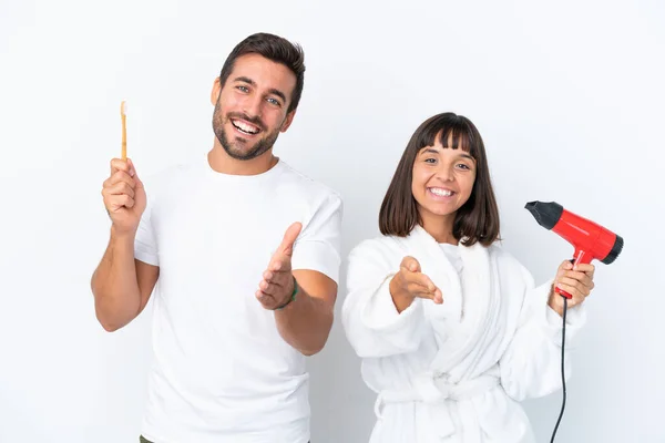 Young Caucasian Couple Holding Hairdryer Toothbrush Isolated White Background Shaking — Fotografia de Stock