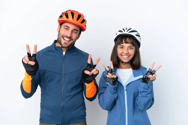 Young Cyclist Couple Isolated White Background Smiling Showing Victory Sign — Stock Fotó