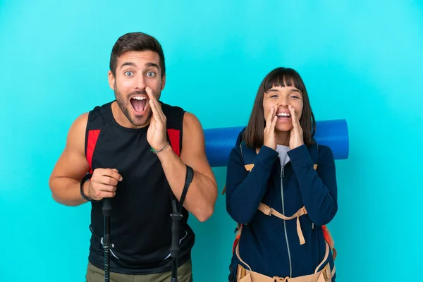 Young Mountaineer Couple Big Backpack Isolated Blue Background Shouting Announcing —  Fotos de Stock