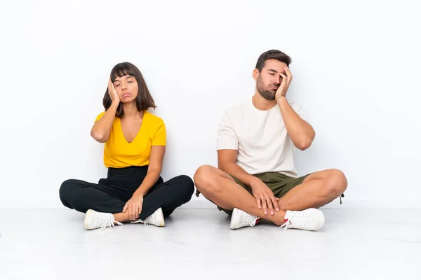 Jovem Casal Sentado Chão Isolado Fundo Branco Com Surpresa Expressão — Fotografia de Stock