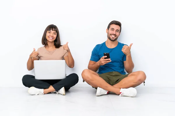 Young Couple Sitting Floor Holding Mobile Phone Isolated White Background — Fotografia de Stock