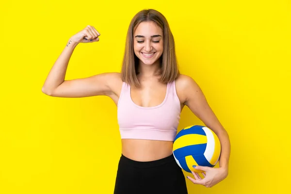 Young Woman Playing Volleyball Isolated Yellow Background Doing Strong Gesture — Stok fotoğraf