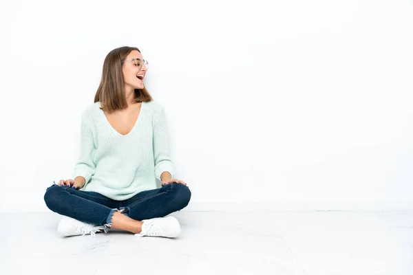 Jonge Blanke Vrouw Zitten Vloer Geïsoleerd Witte Achtergrond Lachen Laterale — Stockfoto