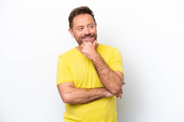 Beyaz arka planda soyutlanmış orta yaşlı beyaz bir adam yan bakıp gülümsüyor.