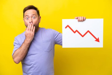 Sarı arka planda izole edilmiş orta yaşlı bir adam elinde azalan bir istatistik okuyla şaşırmış ifade ile bir tabela tutuyor.