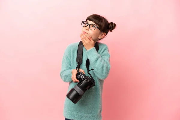 小さな写真家の女の子隔離されたピンクの背景上を見上げながら笑顔 — ストック写真
