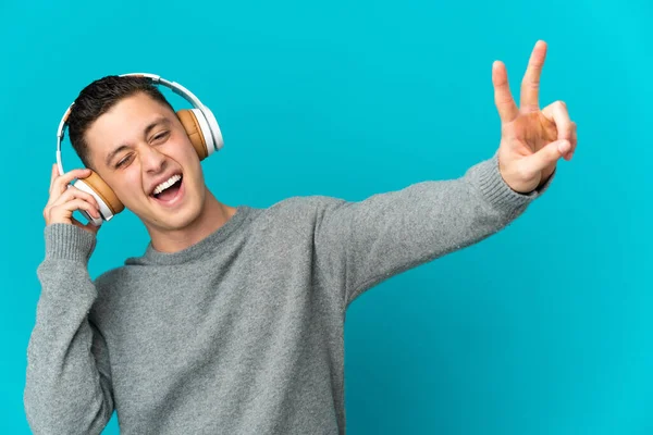 Νεαρός Καυκάσιος Άνδρας Απομονωμένος Μπλε Φόντο Ακούγοντας Μουσική Και Τραγουδώντας — Φωτογραφία Αρχείου