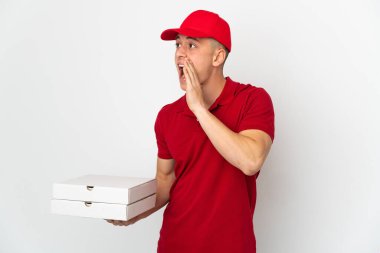 İş üniformalı bir pizzacı beyaz arka planda izole edilmiş pizza kutularını topluyor ve ağzı sonuna kadar açık bağırıyor.