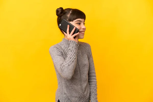 Mała Kaukaska Dziewczyna Odizolowany Żółtym Tle Prowadzenie Rozmowy Telefon Komórkowy — Zdjęcie stockowe