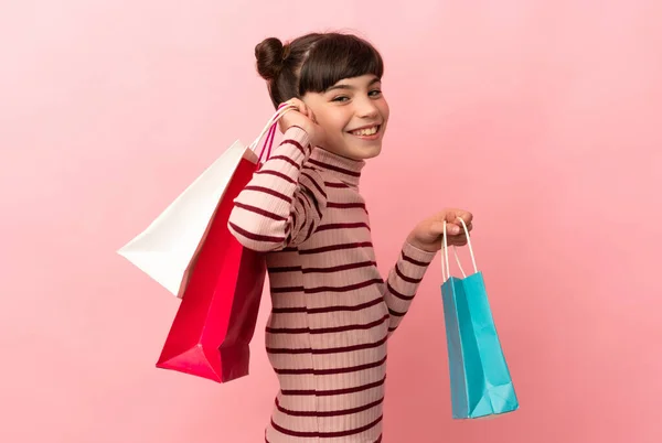 Kleine Kaukasische Mädchen Isoliert Auf Rosa Hintergrund Mit Einkaufstaschen Und — Stockfoto