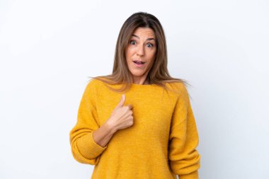 Beyaz arka planda soyutlanmış orta yaşlı beyaz kadın kendini işaret ediyor.