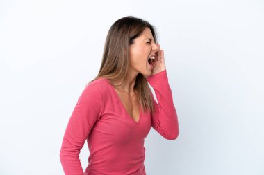 Beyaz arka planda izole edilmiş orta yaşlı beyaz kadın ağzı sonuna kadar açık bağırıyor.