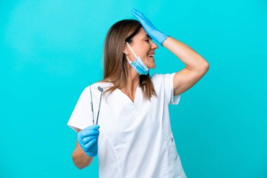 Mavi arka planda izole edilmiş orta yaşlı kadın bir şey fark etti ve çözümü arıyor.