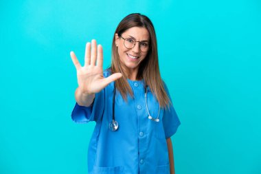 Mavi arka planda izole edilmiş orta yaşlı cerrah kadın parmaklarıyla beşi sayıyor.