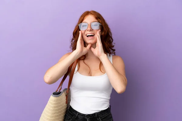 ティーネージャーRedhead女の子保持Aビーチバッグ孤立オン紫背景叫びと何かを発表 — ストック写真