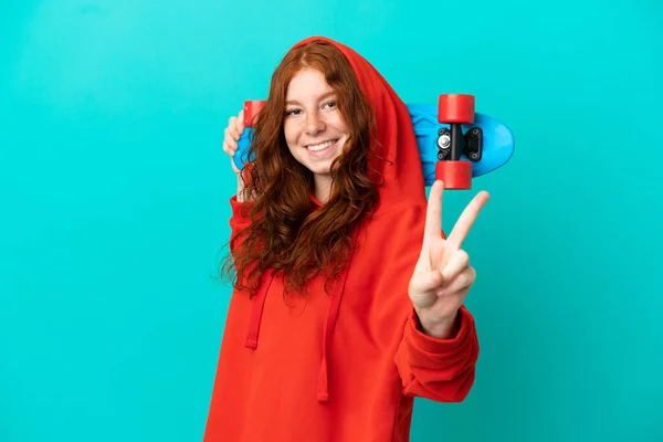 Έφηβος Κοκκινομάλλα Κορίτσι Απομονωμένη Μπλε Φόντο Ένα Πατινάζ Κάνει Χειρονομία — Φωτογραφία Αρχείου