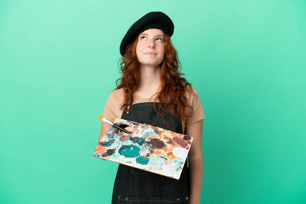 Teenager Redhead Artist Holding Palette Isolated Green Background Looking — Stock Photo, Image