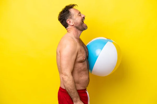 Middle Age Caucasian Man Holding Beach Ball Isolated Yellow Background — Fotografia de Stock