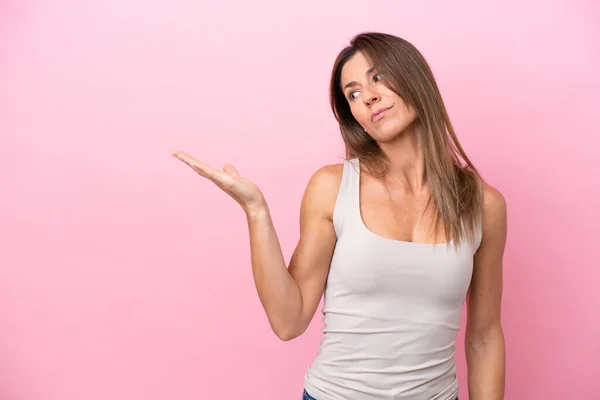 Mujer Caucásica Mediana Edad Aislada Sobre Fondo Rosa Sosteniendo Copyspace — Foto de Stock