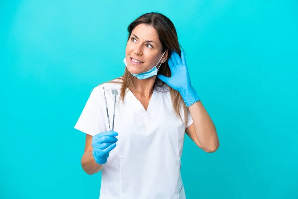 Médico Meia Idade Mulher Isolado Fundo Azul Ouvir Algo Colocando — Fotografia de Stock