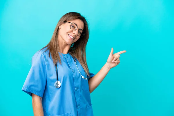 Chirurg Mittleren Alters Frau Isoliert Auf Blauem Hintergrund Zeigt Mit — Stockfoto