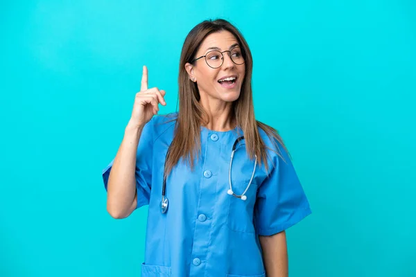 Chirurg Średnim Wieku Kobieta Odizolowana Niebieskim Tle Zamierzając Zrealizować Rozwiązanie — Zdjęcie stockowe
