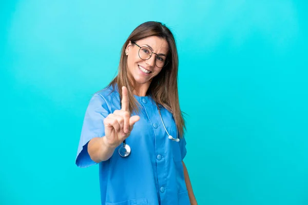 Middle Age Surgeon Woman Isolated Blue Background Showing Lifting Finger — Zdjęcie stockowe