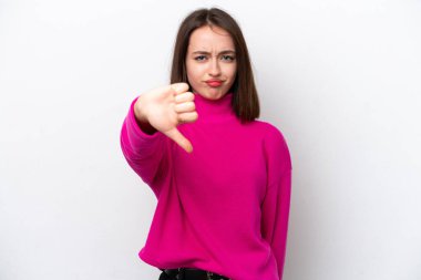 Beyaz arka planda izole edilmiş genç Ukraynalı kadın olumsuz ifadeyle baş parmağını aşağı gösteriyor