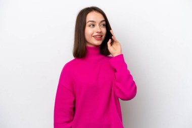 Beyaz arka planda izole edilmiş genç Ukraynalı kadın cep telefonuyla sohbet ediyor.