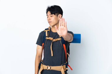 Beyaz arka planda izole edilmiş dağcı Çinli adam dur hareketi yapıyor ve hayal kırıklığına uğruyor.