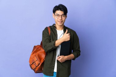 Mor arka planda izole edilmiş genç bir bayan baş parmak hareketi yapıyor.