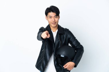 Motosiklet kasklı Çinli bir adam beyaz arka planda izole edilmiş mutlu bir ifadeyle ön tarafı işaret ediyor.