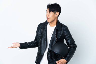 Motosiklet kasklı Çinli bir adam, beyaz arka planda, yana bakarken sürpriz bir ifadeyle izole edilmiş.