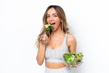 Beyaz arka planda izole edilmiş beyaz bir kadın elinde mutlu bir ifadeyle bir kase salata tutuyor.