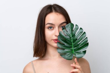 Young Ukrainian woman isolated on white background holding a palm leaf. Close up portrait