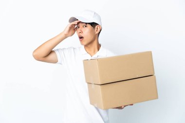 Beyaz arka planda izole edilmiş Çinli bir teslimat. Yan tarafa bakarken sürpriz jest yapıyor.