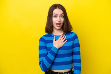 Sarı arka planda izole edilmiş genç Ukraynalı kadın sağa bakarken şaşırmış ve şok olmuştu.